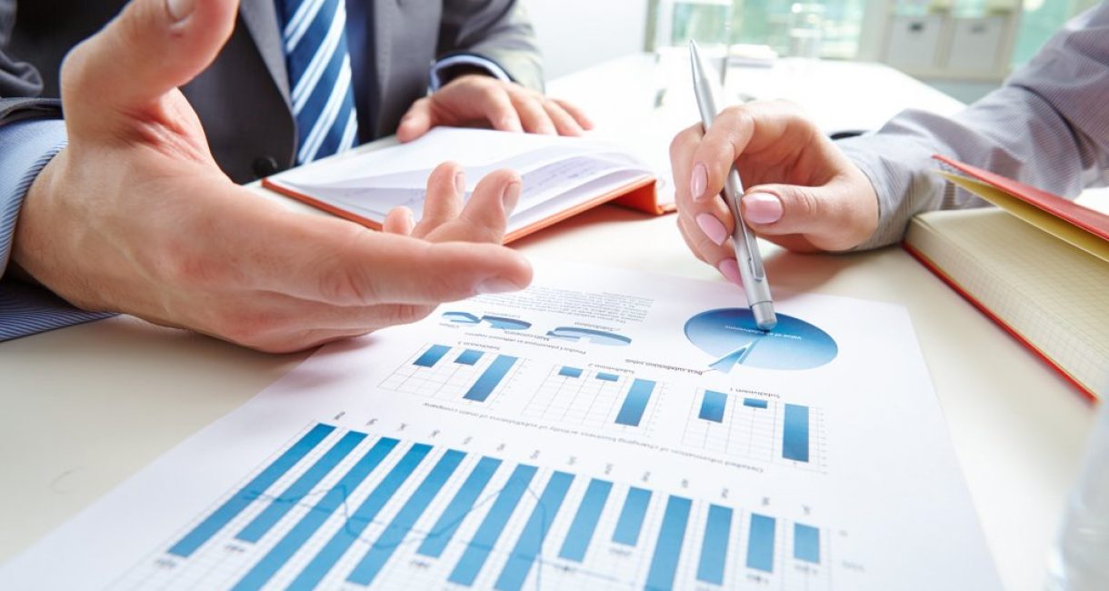 Businessman pointing at document while discussing it with colleague at meeting